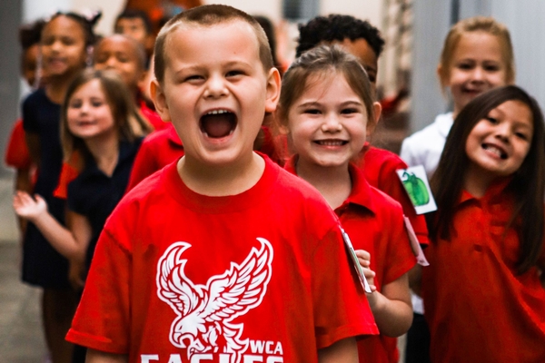 Lower school students in line looking very happy.