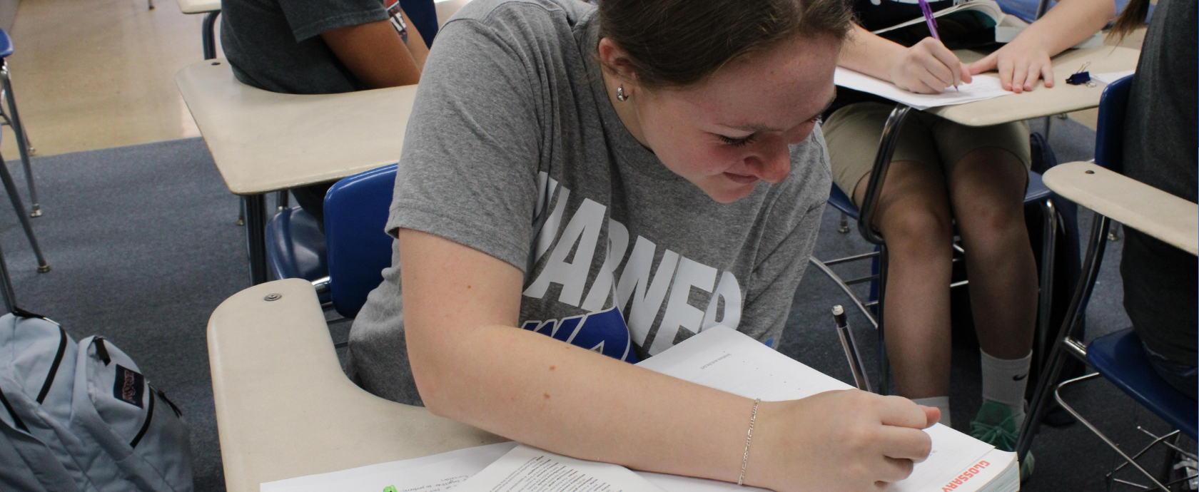 Upper School student taking notes in class.  Discovering TRUTH in Academics.