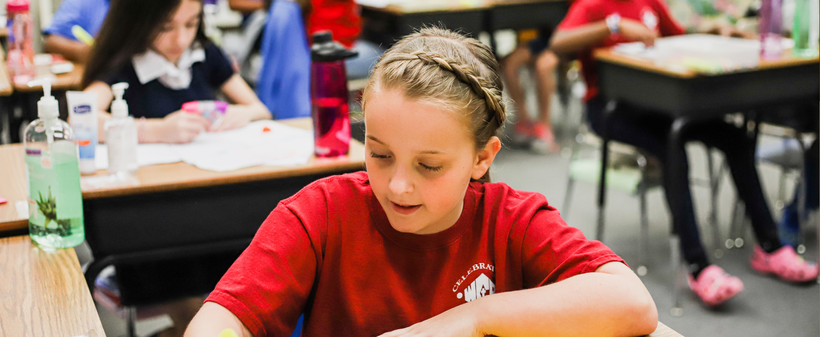 Lower school student taking notes in class. Discovering TRUTH in Academics.